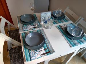 哈尔基岛Casa Bianco e Blu的一张带盘子和玻璃杯的白色桌子