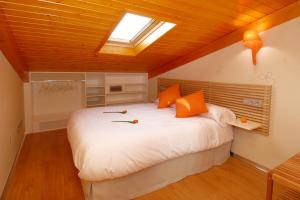 布尔戈斯利姆博姆宾旅馆的卧室配有带橙色枕头的大型白色床