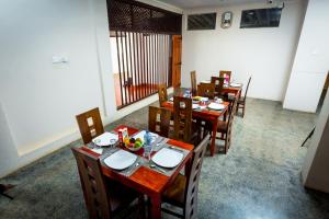贾夫纳Dayanithi Guest House的用餐室配有桌椅和食物