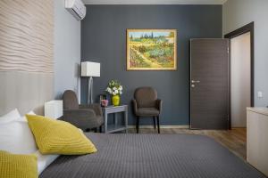 索契Hotel Grafit的卧室配有一张床、一张桌子和椅子
