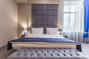 阿拉木图蓝宝石大酒店 的一间卧室配有一张大床和大床头板