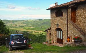 基安蒂格雷夫Agriturismo Poggio all'Olmo的停在石头房子前面的汽车