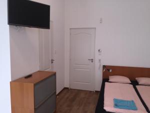 布达佩斯布达佩斯欧米茄酒店的一间卧室设有两张床,墙上配有电视。