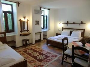 达利安快乐科圆旅馆的一间卧室设有两张床、一张桌子和窗户。