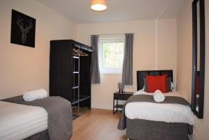 利文斯顿Kelpies Serviced Apartments Callum- 3 Bedrooms- Sleeps 6的一间卧室设有两张床和窗户。