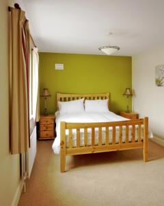 本拉提Bunratty Holiday Homes的一间卧室设有一张床和绿色的墙壁