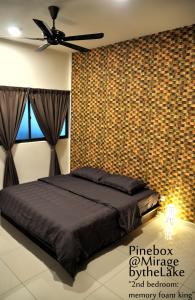 塞贝维PineBox Cyberjaya的一间卧室设有一张床和砖墙