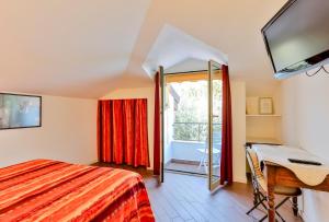 圣雷莫Cà De Rossana Bed&Breakfast的一间卧室配有一张床、一张书桌和一个窗户。
