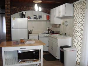 BessemerHusky House的厨房配有白色橱柜和带微波炉的台面。