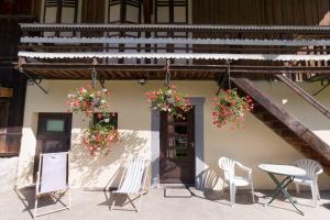 莫尔济讷Maison de la coutetta的庭院配有椅子、桌子和鲜花