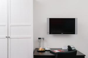 温哥华莫达酒店的一间设有一张桌子的房间,墙上有一台电视机