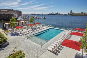 巴尔的摩萨加摩尔巴尔的摩酒店的水边带椅子和遮阳伞的游泳池
