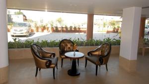 舍地Sai Palace Budget Hotel的大堂设有三把椅子、一张桌子和一辆汽车