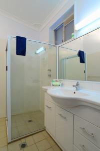 格伦因尼斯休息点汽车旅馆的白色的浴室设有水槽和淋浴。