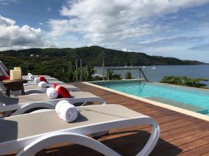 普拉亚埃尔莫萨Hotel La Gaviota Tropical的游泳池旁的一排躺椅