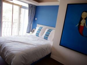 香港海悠居的一间卧室配有一张蓝色墙壁的床