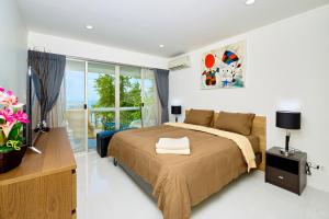 乔木提恩海滩LUXURIOUS APARTMENT at VILLA NAVIN, 30's JOMTIEN BEACH的一间卧室设有一张床和一个大窗户