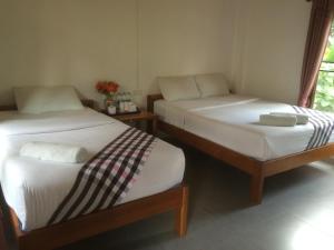 拜县paibaansuan的带窗户的客房内设有两张单人床。