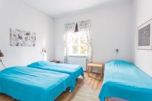 Romakloster罗马村庄布鲁克斯住宿加早餐旅馆的白色客房的两张床,配有蓝色的床单