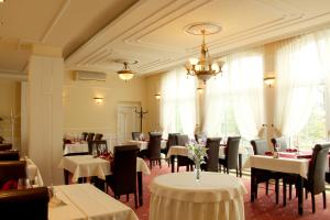 布拉迪斯拉发Luxury Garni Hotel Brix的一间带桌椅和吊灯的餐厅