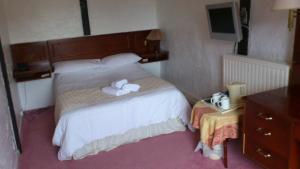 阿特尔伯勒格里芬酒店的一间卧室配有一张床,上面有两条毛巾