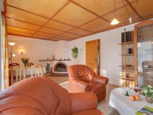 青斯特Tranquil Holiday Home in Zingst Germany with Terrace的客厅配有两张真皮座椅和一张桌子