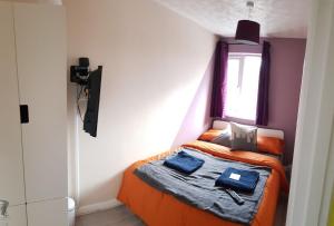 塞特福德Columbine, Thetford, 2BR House的一间小卧室,配有一张橙色床和窗户