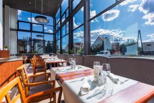 绿山城锡隆纳葛拉奎巴斯酒店的餐厅设有木桌和椅子以及大窗户。
