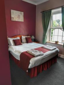 ParkendThe Fountain Inn的一间卧室设有一张带红色墙壁的大床