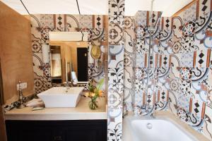 Douar Caïd LayadiVilla Dinari的一间带水槽、浴缸和镜子的浴室