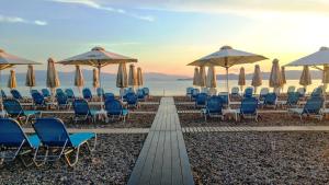 沃拉哈蒂阿尔克扬Spa度假酒店的海滩上的一组椅子和遮阳伞