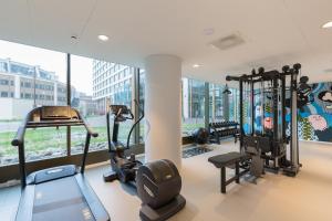 鹿特丹鹿特丹尊贵套房公寓的带有氧器材的健身房,位于带窗户的大楼内