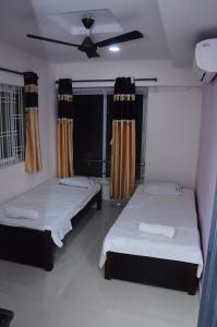 蒂鲁帕蒂SGS Residency的一间卧室配有两张床和吊扇