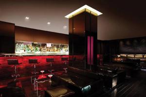 拉斯维加斯棕榈广场豪华套房酒店的一间设有酒吧的客房,配有红色的椅子和桌子