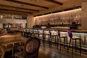 拉斯维加斯棕榈广场豪华套房酒店的餐厅设有酒吧、椅子和柜台