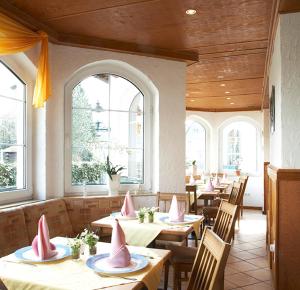 伊瑟隆道特餐厅酒店的餐厅配有桌椅和粉色餐巾