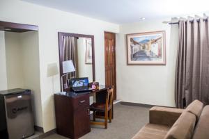 卡哈马卡Hotel Cajamarca的客房设有一张桌子、一台电脑和一张沙发