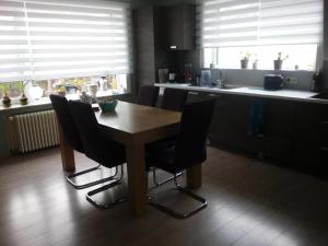 克诺克－海斯特Kamer + douche in villa的厨房配有木桌和黑色椅子