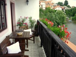 捷克克鲁姆洛夫普拉斯维卡119宾馆的一个带长椅和鲜花的阳台,以及河流