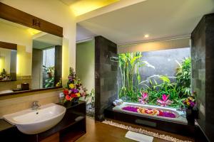 乌布古里乌布餐厅Spa度假村 的浴室设有大型水族箱,毗邻水槽