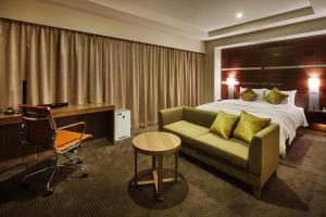 新泻JR-EAST Hotel Mets Niigata的酒店客房配有一张床、一张沙发和一张书桌。