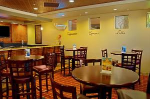 梅萨Legacy Inn & Suites的一间带桌椅的餐厅和一间酒吧