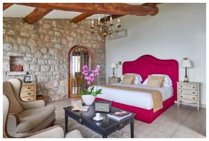 艾日金羊酒店的一间卧室设有一张大床和石墙