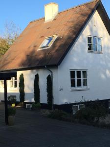 尼克宾摩斯Heltoften Bed & Breakfast的白色房子,有棕色的屋顶
