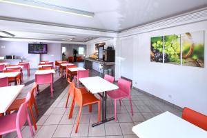 瑟农弗姆勒斯2号俱乐部酒店的用餐室配有桌子和红色椅子
