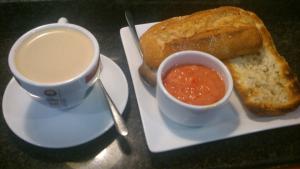 阿罗约莫利诺斯V Hotel的盘子,盘子上放着咖啡和面包,还有汤