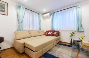东京Haneda Luxury House的客厅的沙发配有蓝色窗帘