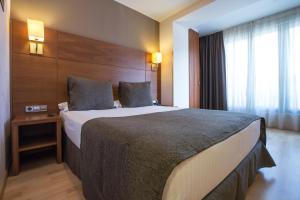 巴塞罗那维亚奥古斯塔酒店的一间设有大床和窗户的酒店客房