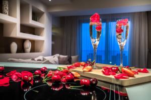 蒂锡利维Kymothoe Elite Suites的两杯香槟酒,放在带红花的柜台上