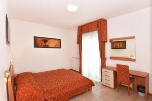 卡奥莱奥尔加别墅酒店的一间卧室配有一张床、一张书桌和一个窗户。